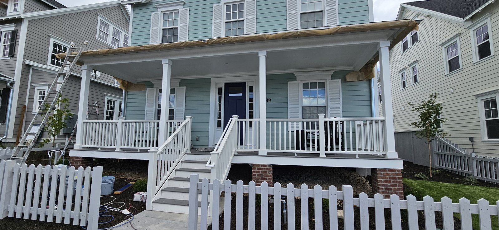 House with freshly painted blue siding, white trim, and black shutters in Utah.