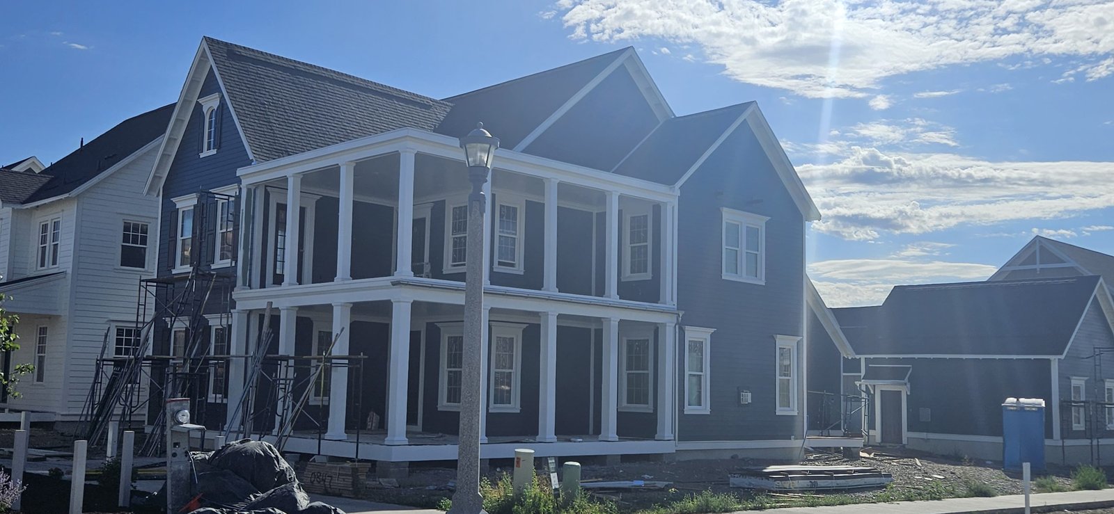 Utah home with expert exterior painting featuring dark blue siding, white trim, and black shutters.