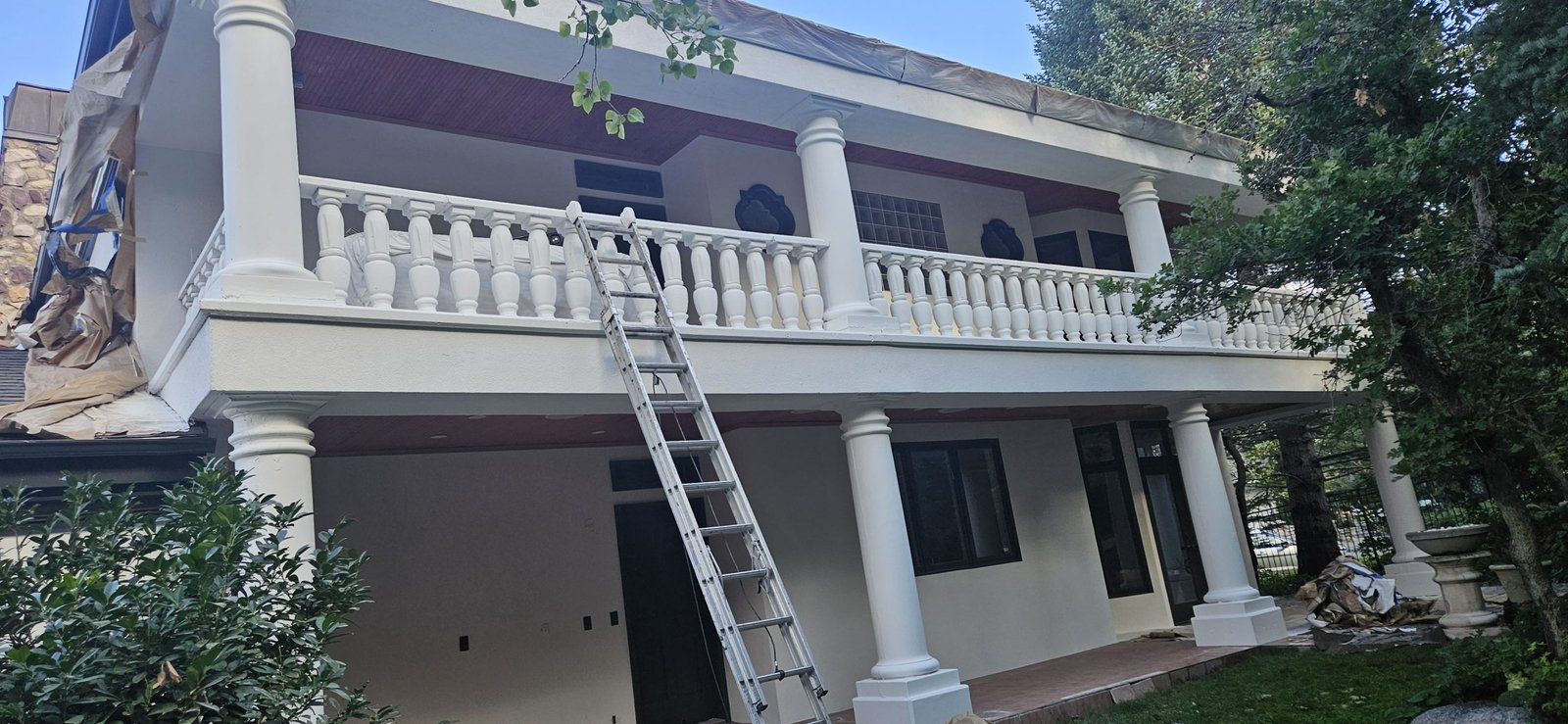 Exterior home renovation in Utah, featuring painted columns and balcony railings.