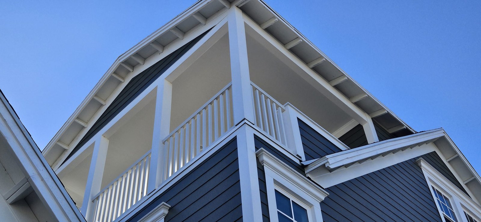 Utah home with freshly painted exterior, featuring white columns and balcony railings.