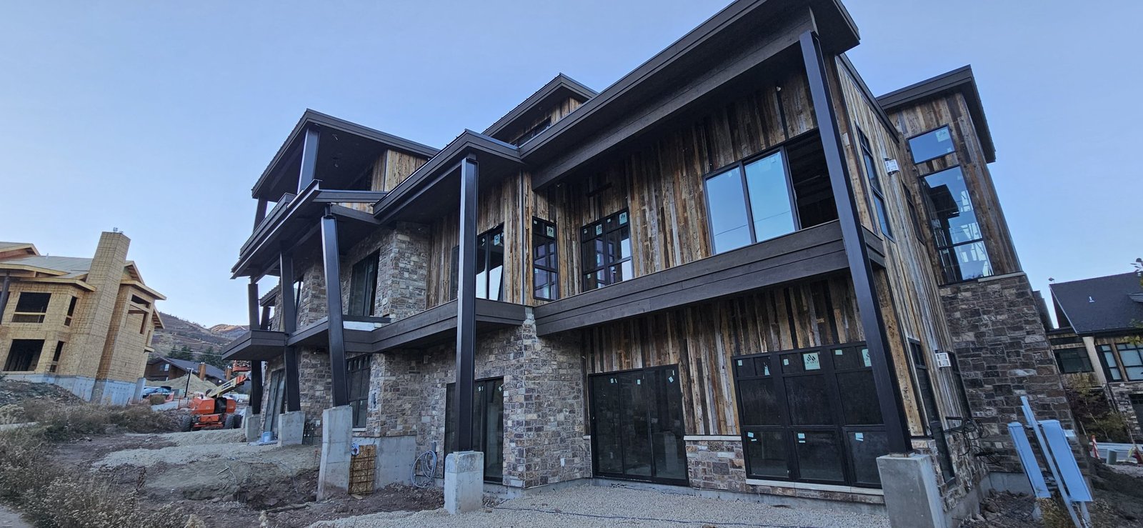 Park City, Utah home under construction featuring stone cladding, wood siding, and large windows.