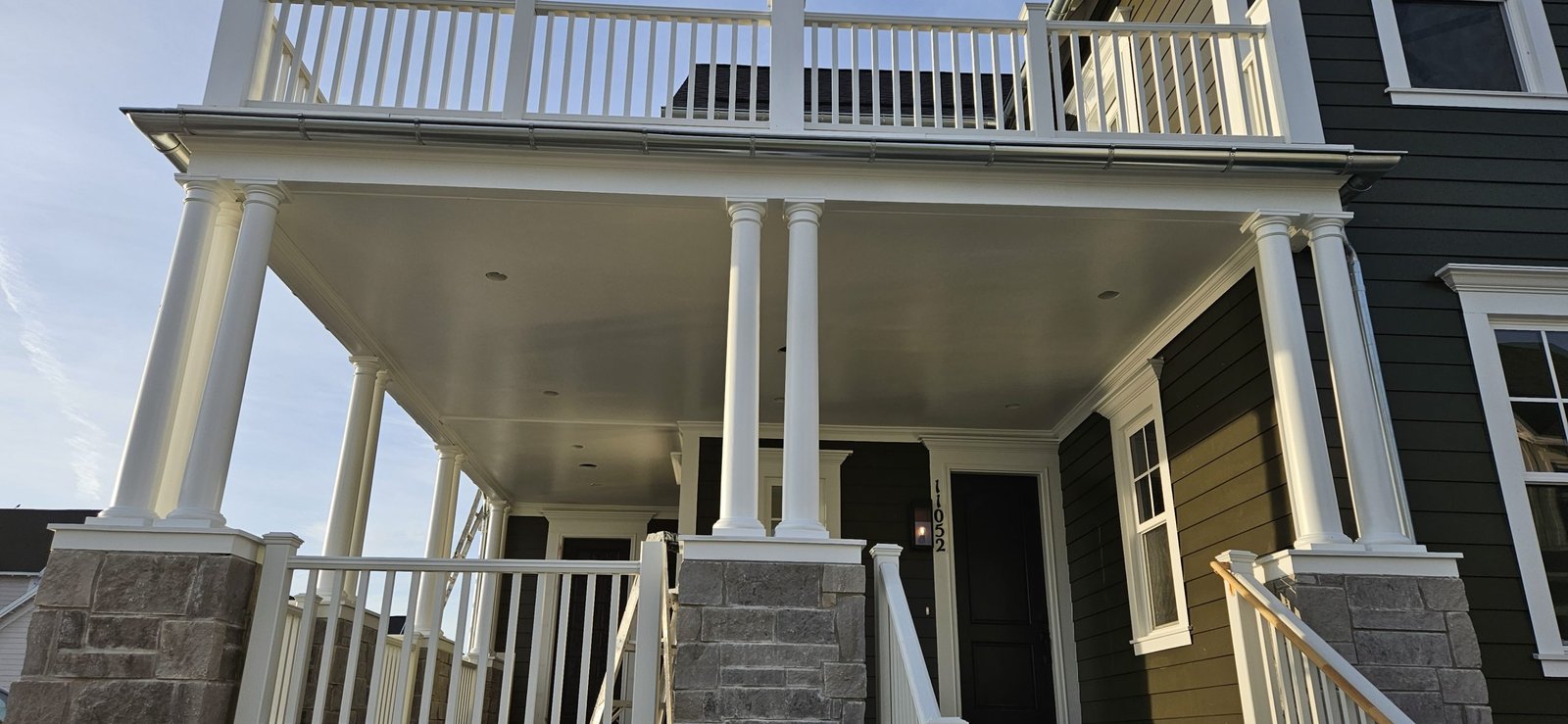 Utah home with a newly painted porch featuring white columns and railings