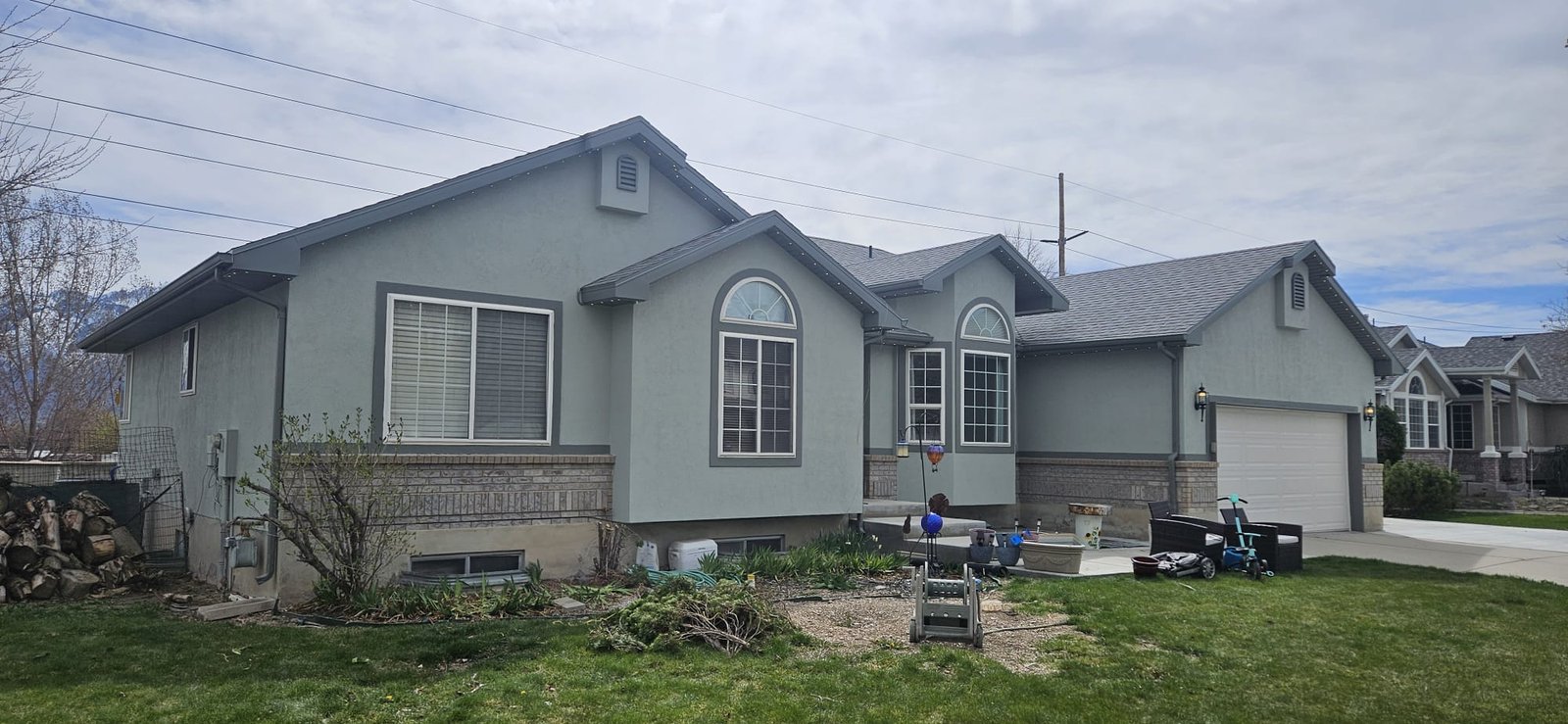 Utah home with newly painted gray siding, white trim, and shutters.