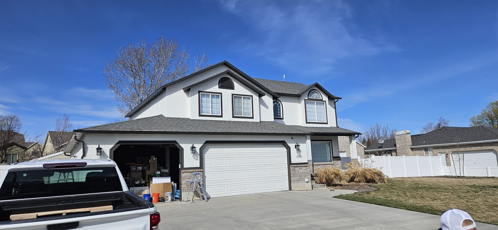 painted Utah home with white exterior, gray roof, and white picket fence.