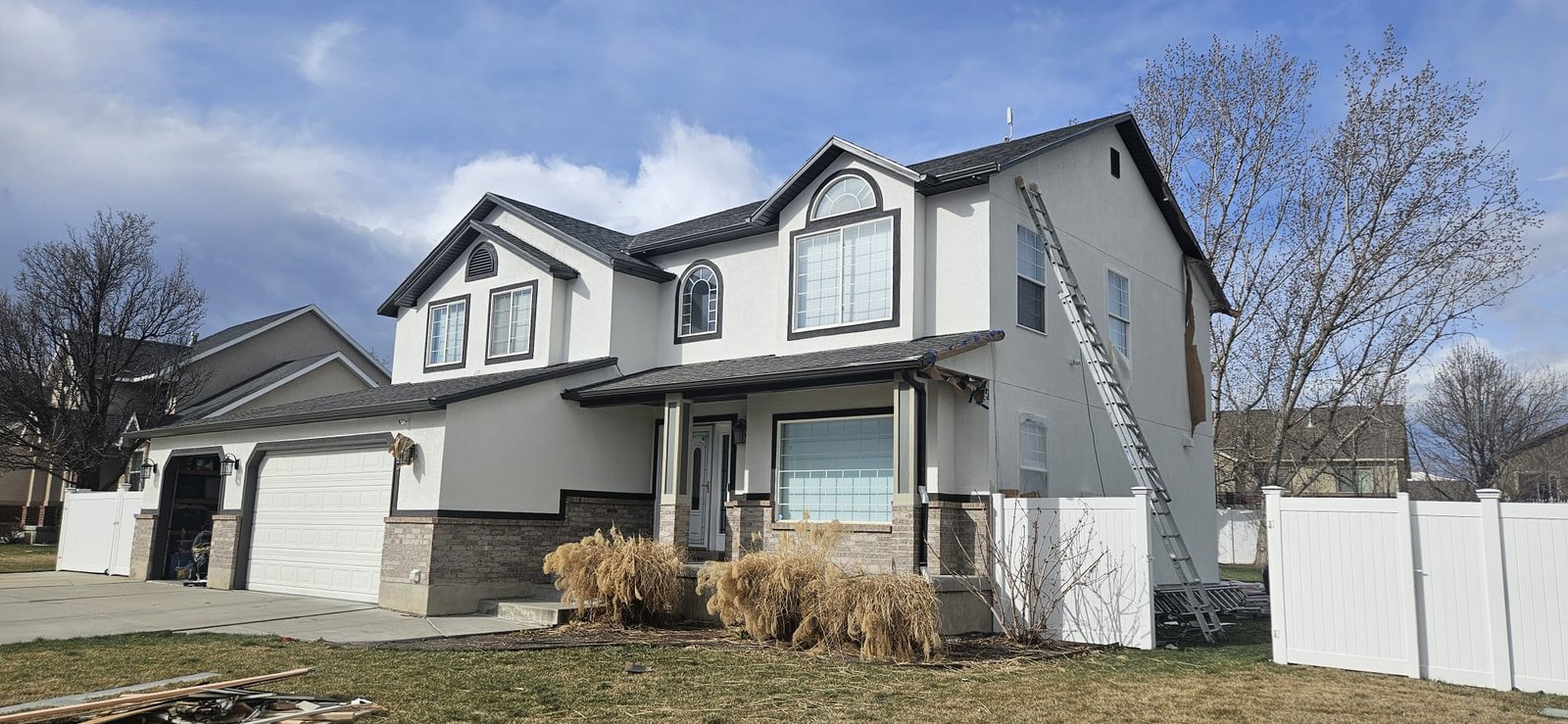 Utah home with white stucco exterior, black accents, and gray roof.