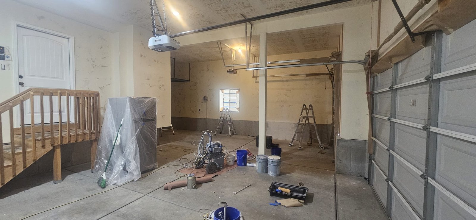 Garage interior being transformed with fresh paint.