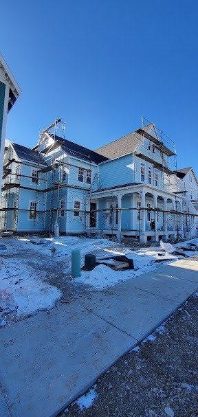 Utah home under construction featuring blue siding, white trim, and scaffolding.