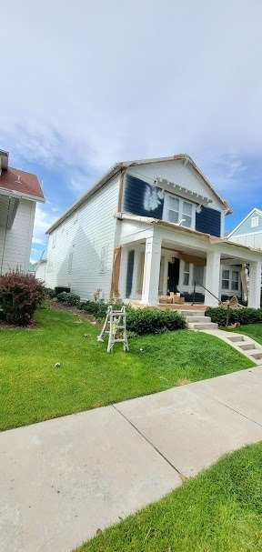 House exterior painting project in Utah, featuring white siding and scaffolding.