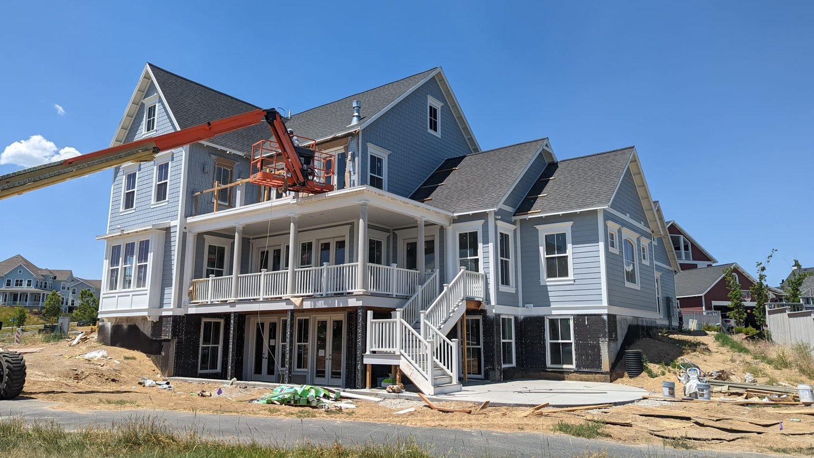 Professional exterior painting on a new construction home with a gray color scheme and white trim.